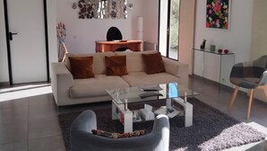 Un salon moderne avec un canapé, une table basse et un mur décoratif agrémenté d’un miroir.