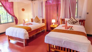Une chambre avec deux lits en bois, chacun étant équipé d’un oreiller et d’une lampe.