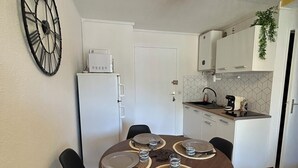 Eine kleine Küche mit weißen Schränken, einer Mikrowelle und einem Spülbecken.