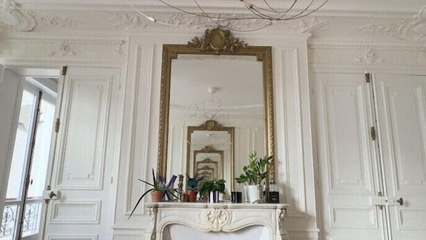 A room with a white fireplace, a large mirror, and a ceiling with intricate designs. - Spacious, Quiet and Elegant Apartment in Paris (Paris)