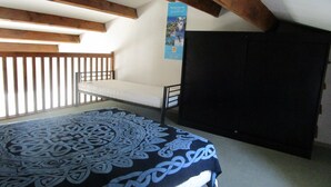 Ein Schlafzimmer mit Bett, Kleiderschrank und einem Fenster mit Blick.