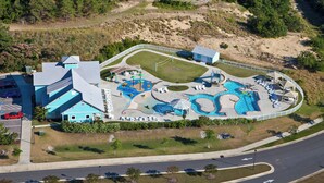 Luchtbeeld van een resort met een groot zwembadgedeelte, meerdere glijbanen en een parkeerplaats.