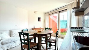 Eine moderne Küche mit Essbereich, einer Sitzecke und Blick ins Freie.