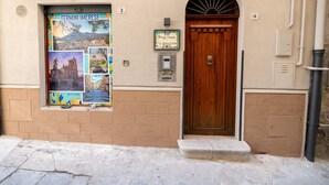 Ein Gebäude mit einer Holztür, einem Briefkasten und einem Plakat an der Wand.