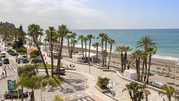 A coastal road with palm trees, a beach, and a clear sky. - Beachfront Vacation Apartment - Almunecar (Almunecar)