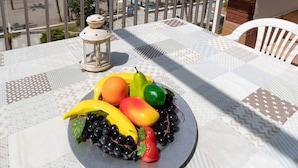 A table with a fruit platter, a lantern, and a view of the beach and ocean. - Beachfront Vacation Apartment - Almunecar (Almunecar)