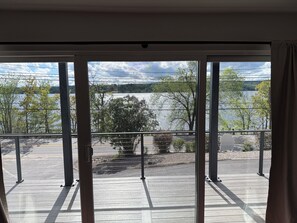 A balcony with a view of a lake, trees, and a clear sky. - Beautiful 4BR Lake House - New 2026 - Boat Slip - Located on Large Compound (Laconia)