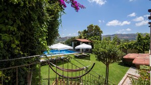 A pool area with umbrellas, a hammock, and a view of the landscape. - Kissamos Luxury Villa for 4 Guests (Kissamos)