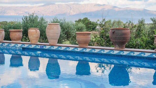 A pool with terracotta pots lined up along the edge, a tiled border, and a mountainous landscape in the background. - Kissamos Luxury Villa for 4 Guests (Kissamos)