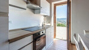 Una cucina moderna con forno a incasso, lavello e finestra con vista su un paesaggio suggestivo.