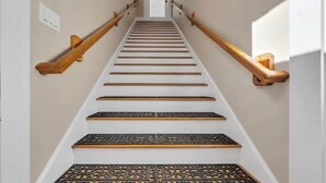 A staircase with wooden handrails and decorative metal railings.