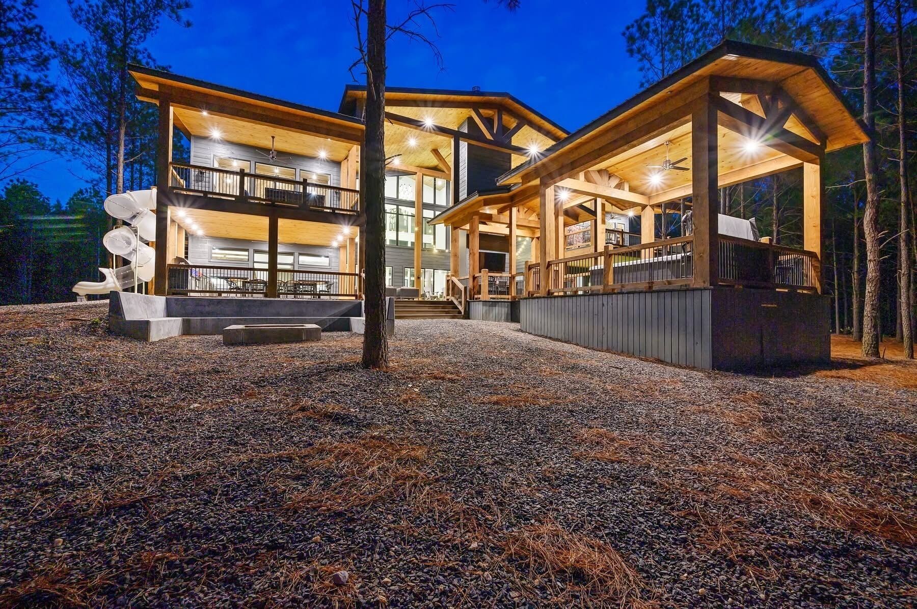 Een modern, meerlaags houten vakantiehuis met buitenmeubels en een overdekt terras.