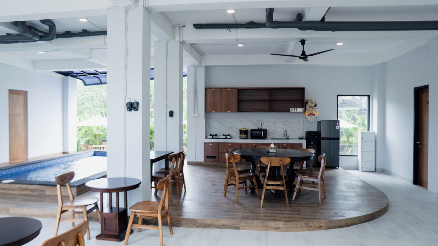 A modern kitchen with a central island, wooden chairs, and a dining table.
