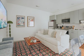 A modern living room with a sofa, coffee table, and a patterned rug.