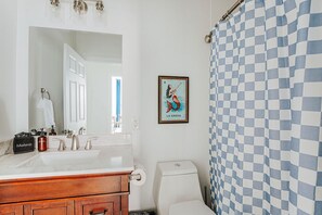 A bathroom with a checkered shower curtain, a sink with a mirror, and a framed picture on the wall. - The Social Loft: Above Reunion, Walk Everywhere! (Staunton)