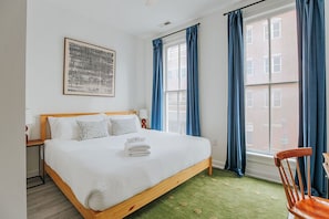 A neatly made bed with white linens, a wooden headboard, and a green carpet. - The Social Loft: Above Reunion, Walk Everywhere! (Staunton)