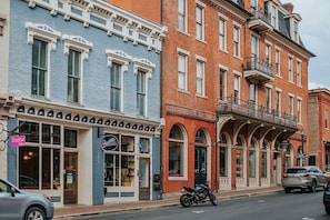 A row of multi-story buildings with commercial storefronts, including a visible sign for a restaurant.