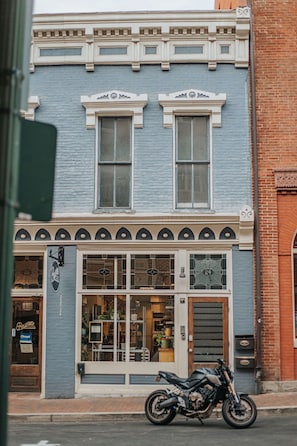 A two-story building with a brick facade, large windows, and a motorcycle parked in front. - The Social Loft: Above Reunion, Walk Everywhere! (Staunton)