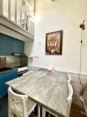 Eine Küche mit Esstisch, Stühlen und einem Bild an der Wand.