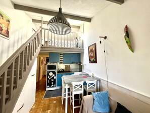 Eine Küche mit Essbereich, einer Treppe und einer Wand mit einem gerahmten Bild.