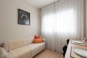 Departamento Deluxe, balcón, vista a la ciudad | Área de sala de estar