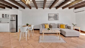 Uma sala de estar moderna com sofá, mesa de centro e área de refeições.