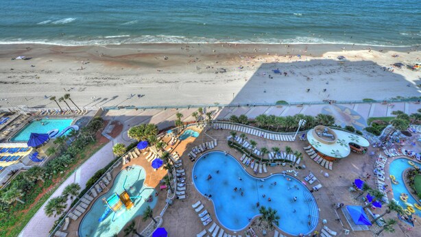 Ein Resort mit mehreren Schwimmbecken, einem Strand und Blick auf den Ozean.