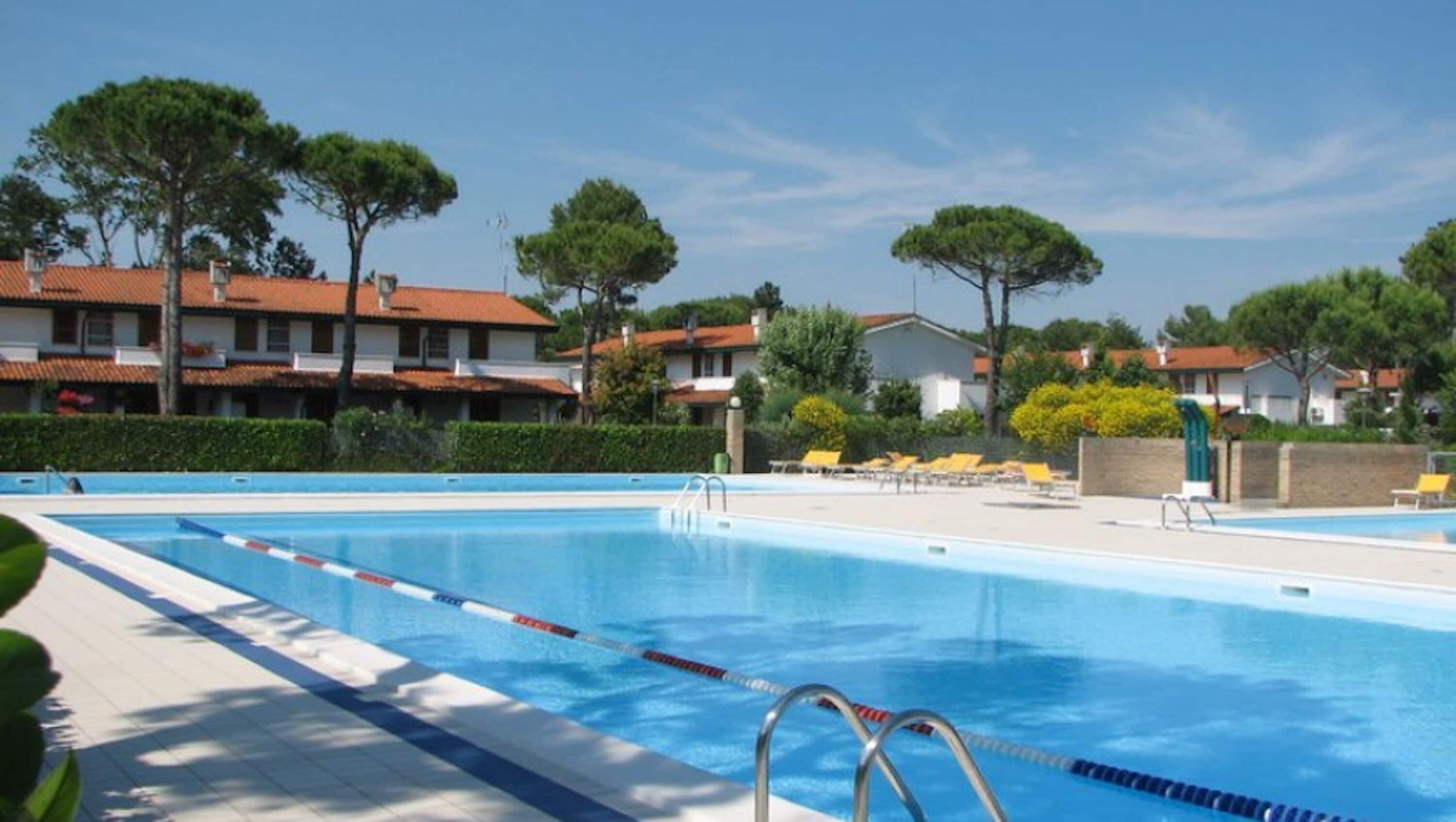 A swimming pool with lane dividers, a pool ladder, and sun loungers.