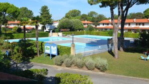 Zona residencial amb piscina, arbres i cases amb teulades vermelles.