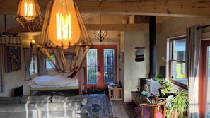 Een gezellige kamer met een bed, een tafeltje, een verwarming en een raam met gordijnen.