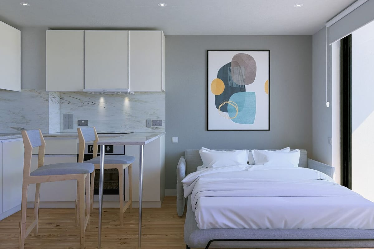 A modern bedroom with a bed, a desk, and chairs.