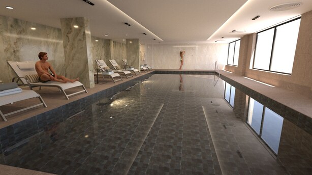 A swimming pool with lounge chairs, a person sitting on one, and a person standing in the water. - Victory Suites (Gibraltar)