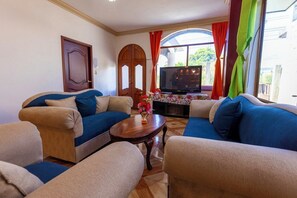 A living room with two sofas, a coffee table, and a TV.