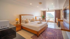 Une chambre d’hôtel avec un lit, une table de chevet, une lampe et une vue sur l’extérieur.