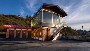 Un bâtiment moderne avec un étage supérieur en verre, un étage inférieur en briques et un escalier menant à l’étage supérieur.