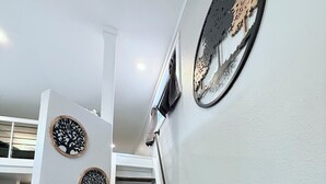 Una escalera con barandilla, un cuadro en la pared y tres adornos en forma de árbol.