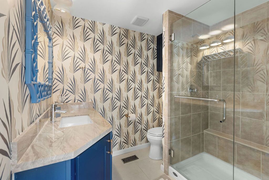 Une salle de bain avec douche, toilettes et lavabo.