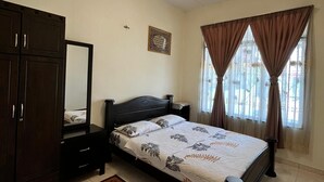 Une chambre à coucher comprenant un lit, une armoire, un miroir, une table de chevet, une fenêtre avec des rideaux et un luminaire au plafond.
