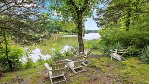 A lakeside setting with Adirondack chairs and a natural landscape.
