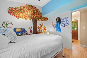 A bedroom with a bed, a wall mural, and a door leading to another room. - Lakefront Home on Old Hickory Lake (Old Hickory)