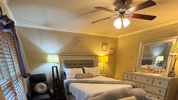 A bedroom with a bed, two chairs, a ceiling fan, a dresser, and a mirror. - FIFA READY! Spacious 8-bedroom Retreat in Stone Mountain (stone mountain)