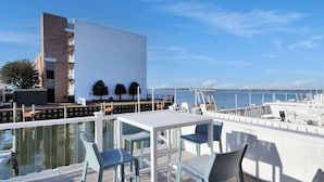 En tagterrasse med pool, udendørs møbler og havudsigt.