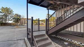 A staircase leading to an upper level, a metal railing, and a sign on the wall. - Jamaica Bay 308B (Ocean City)