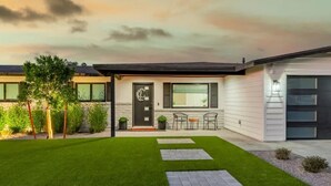 Een modern huis met een verzorgd gazon, een voordeur en een garage.