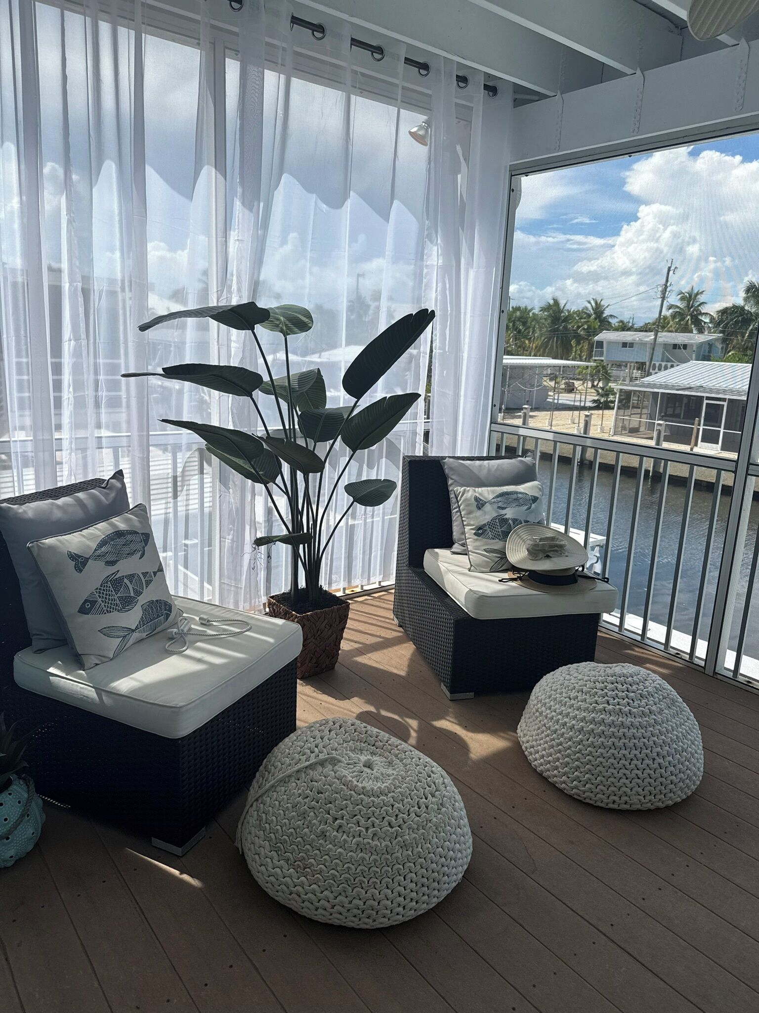 Ein Balkon mit zwei Korpus-Sofas, einem Topf mit Pflanze und zwei runden Hocker.