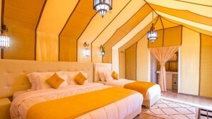 A room with two beds, a sofa, and a small table. - Sahari Merzouga Camp (Merzouga)