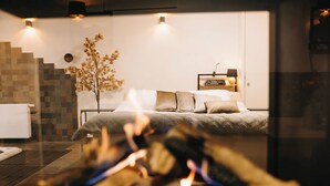 Een moderne slaapkamer met een bed, een nachtkastje, een wandlamp en een trap.