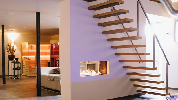 Een modern interieur met een zwembad, een houten trap en een keuken.