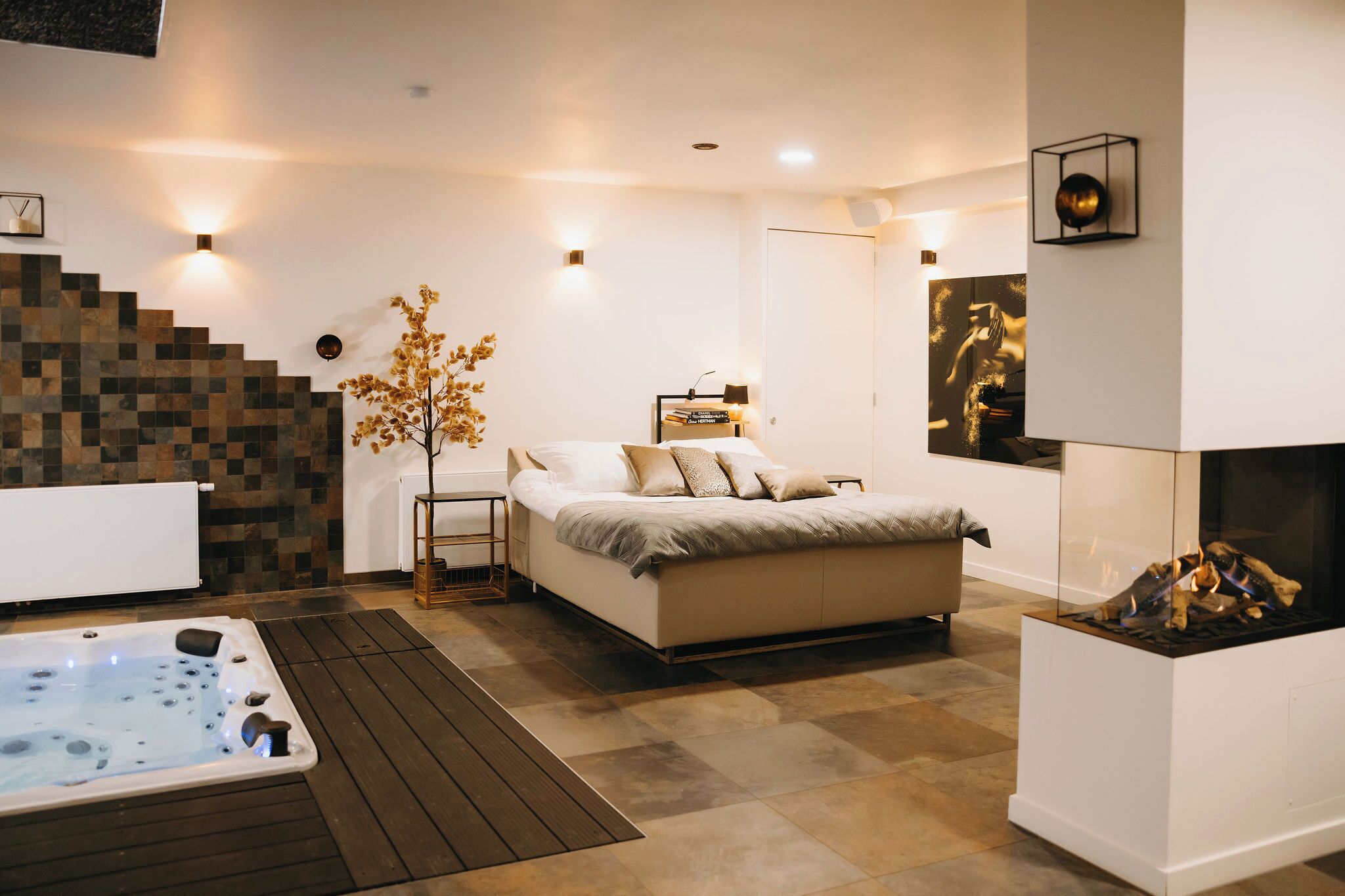 Un dormitorio moderno con una cama grande, un jacuzzi y una chimenea.