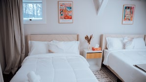 Ett hotellrum med två sängar, ett fönster med gardiner och två målningar av Henri Matisse på väggen.